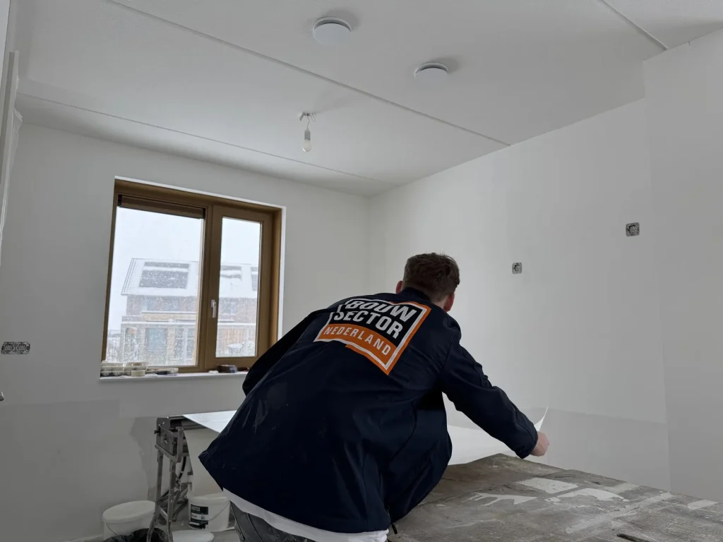 Behanger van Bouwsector Nederland pakt een baan vlies van de plaktafel