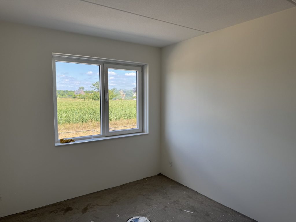 Kale slaapkamer in een nieuwe woning met uitzicht over het land
